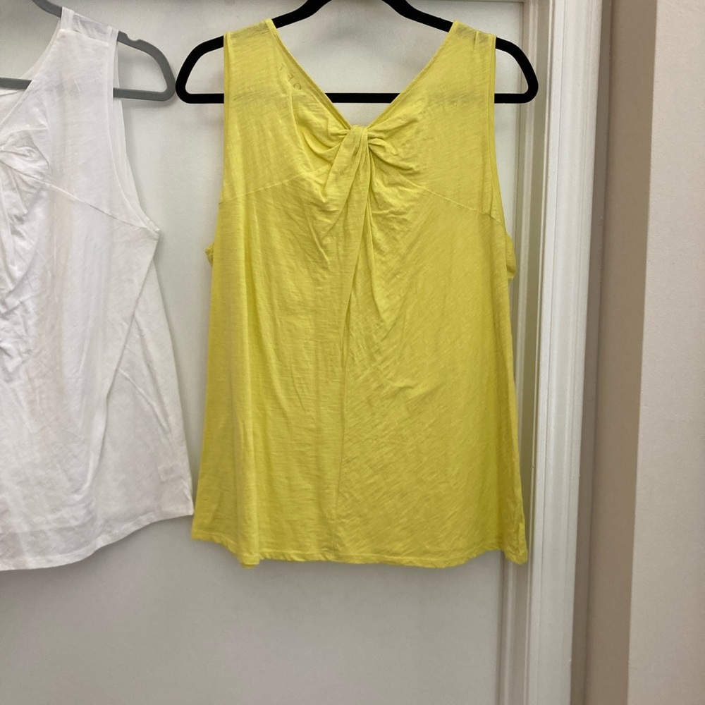 Yellow and white t shirts with tie at top.
